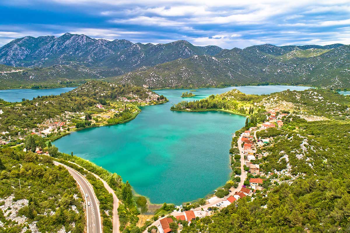 Adriatic coastline with historic stone rooftops and clear blue water in Dalmatia.
