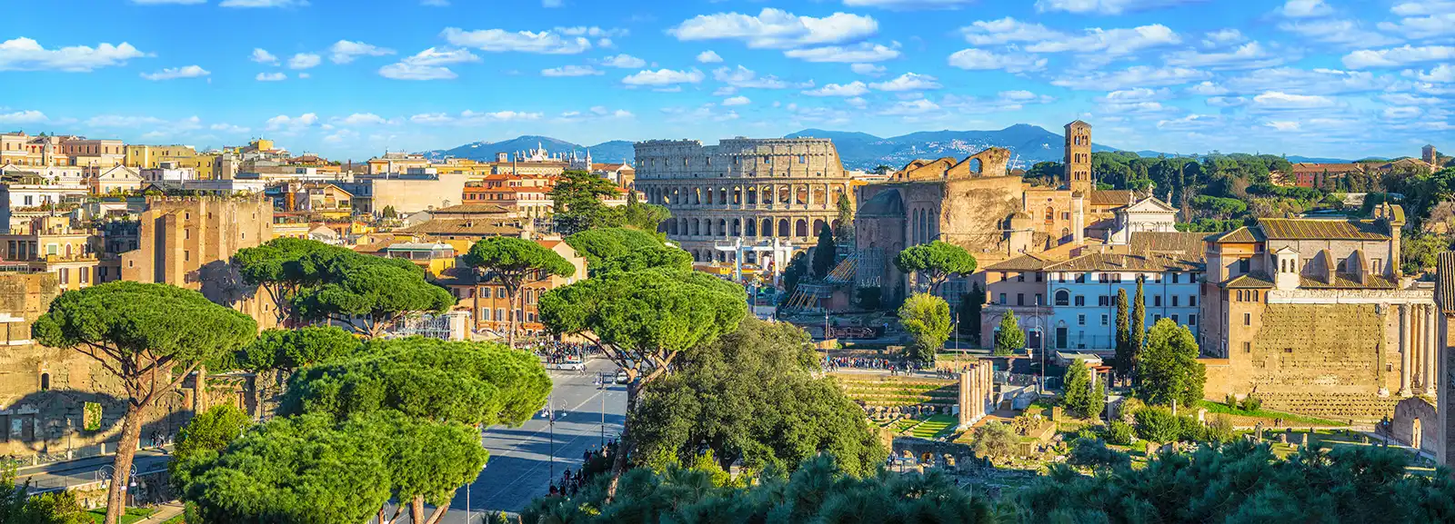 Columns and brick masses of ancient Roman ruins in warm evening light in the heart of Rome.
