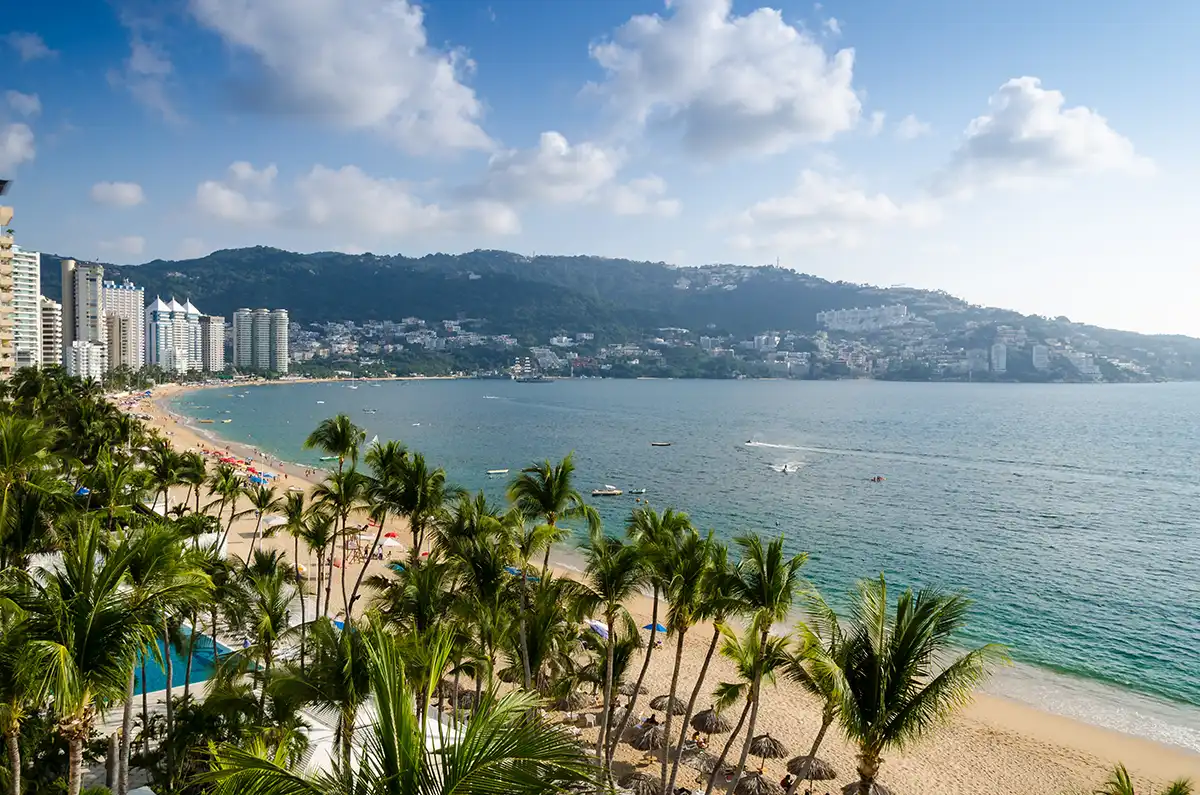 Acapulco's bay curving between Pacific headlands, high-rises lining the shore.