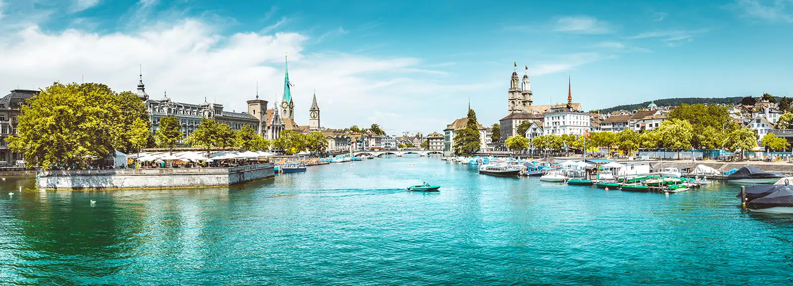 El casco antiguo de Zúrich junto al Limmat, con campanarios sobre los tejados y puentes cruzando el río.